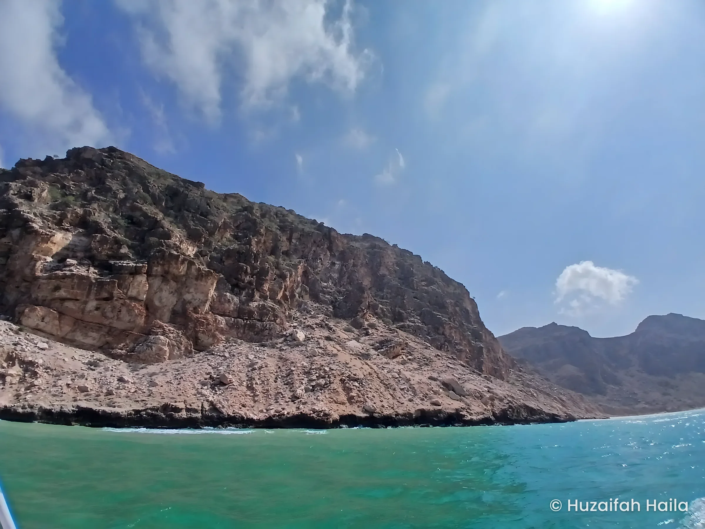 Rocky cliffs and a headland above turquoise water